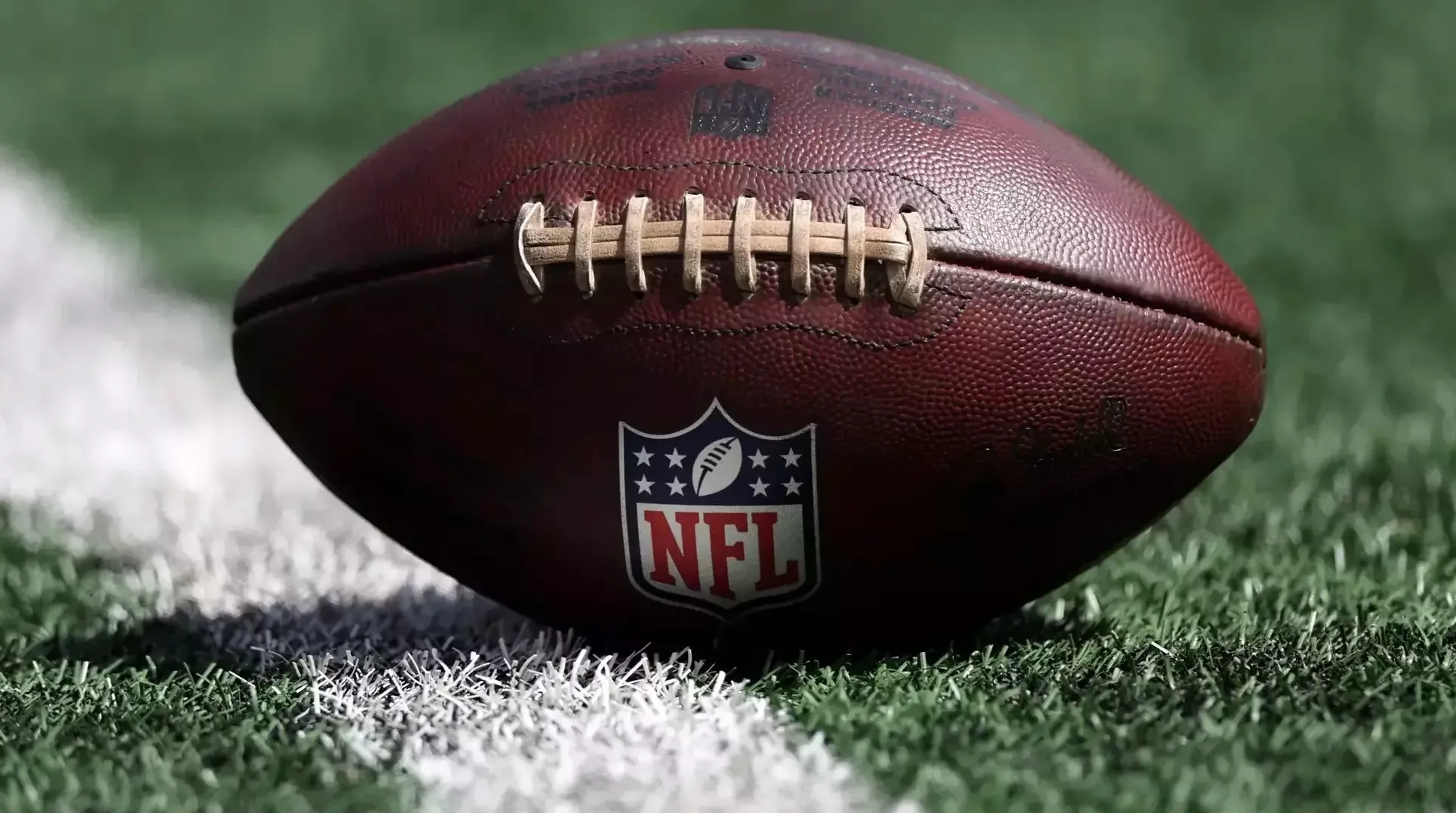 football resting on green grass field